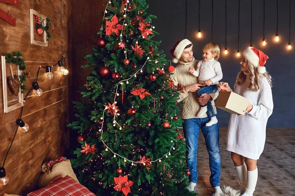 Family decorates the Christmas tree in the room at Christmas