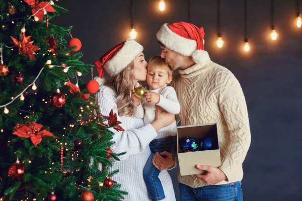 Familie schmückt zu Weihnachten den Weihnachtsbaum im Zimmer — Stockfoto