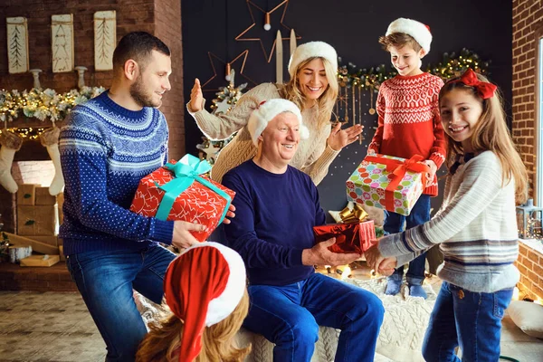 A big family in a room gives gifts at Christmas. — Stock Photo, Image