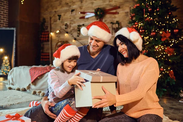 La familia da un regalo en la habitación para Navidad — Foto de Stock