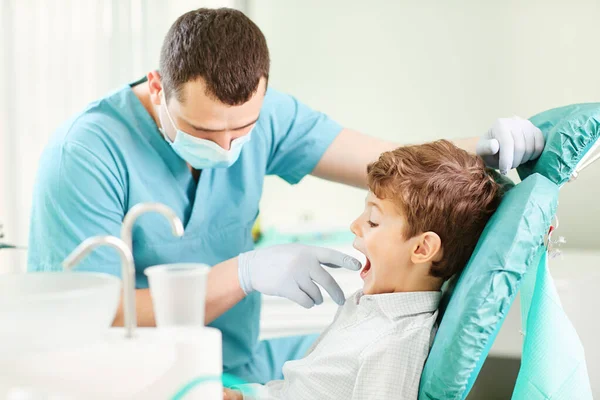 Chłopiec dziecko i dentysta sprawdzą zęby w lustrze. — Zdjęcie stockowe