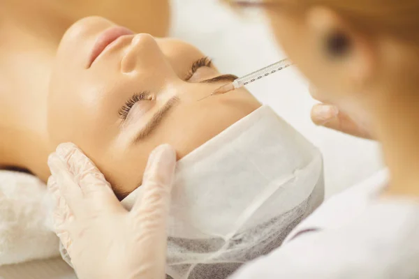 Cosmetology médico faz injeções de beleza no rosto de uma mulher . — Fotografia de Stock