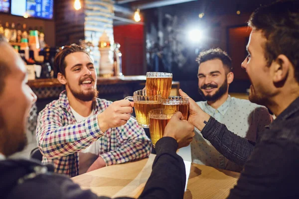 Amigos tazas de cerveza tintineo en bar —  Fotos de Stock