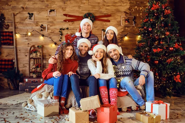 Felices amigos con regalos de Navidad cerca del árbol de vacaciones —  Fotos de Stock