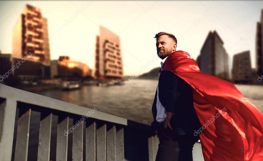 Successful superhero businessman on a business building background