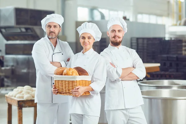 W piekarni uśmiecha się grupa piekarzy — Zdjęcie stockowe