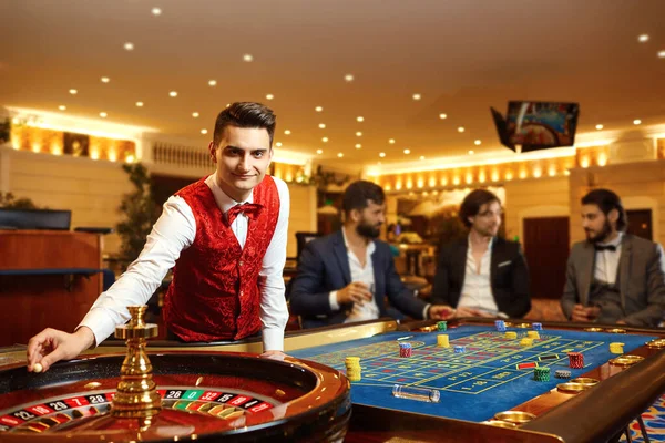 Ένας κρουπιέρης δουλεύει σε μια ρουλέτα πόκερ σε ένα καζίνο. — Φωτογραφία Αρχείου