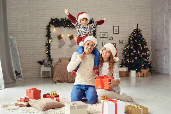 Šťastná rodina v Santas klobouky s úsměvem na Vánoce — Stock fotografie