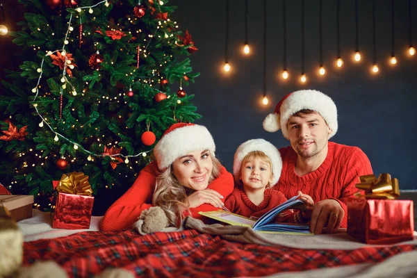 Счастливая семья дома с новогодней елкой — стоковое фото