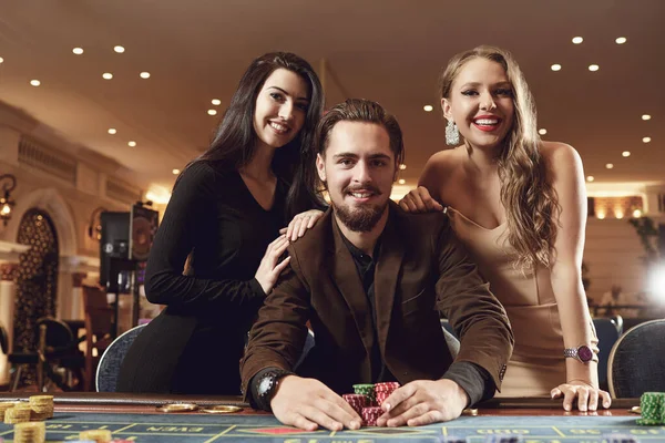 Um homem feliz em um terno leva uma vitória no casino de poker roleta . — Fotografia de Stock