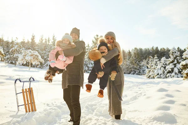Playful couple with kids in winter woods — Zdjęcie stockowe