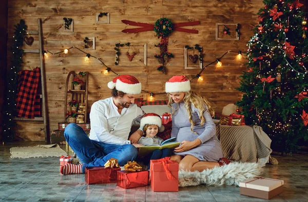Η οικογένεια διαβάζει ένα βιβλίο στο σπίτι τα Χριστούγεννα — Φωτογραφία Αρχείου