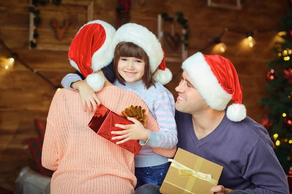 Mother and father with a child give gifts at Christmas — Stock Photo, Image