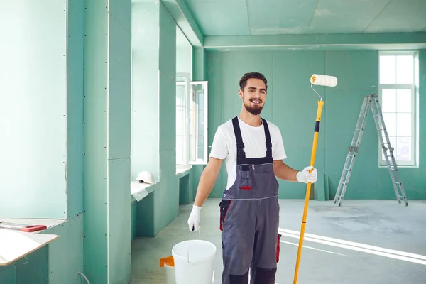 Pintor barbudo trabajador de la construcción en una obra de construcción . — Foto de Stock