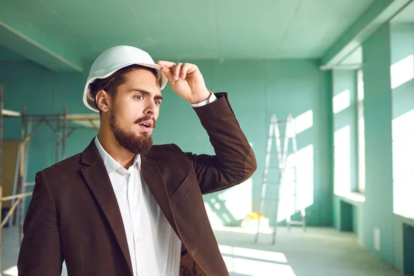 Bauarbeiter mit weißem Helm überrascht bei Baustelle im Innenbereich — Stockfoto