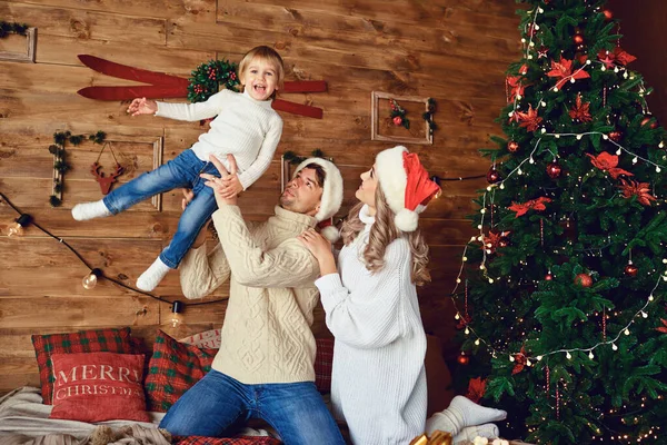 Anya és apa játszanak a gyerekkel a házban karácsonykor. — Stock Fotó