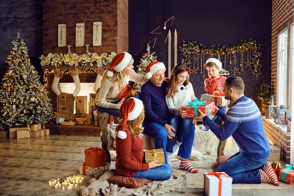 Uma grande família em um quarto dá presentes no Natal. — Fotografia de Stock