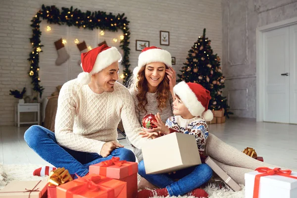 Família dá presentes para a criança em casa para o Natal . — Fotografia de Stock