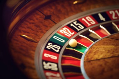 Roulette wheel with a white ball on green at zero number in a casino clipart