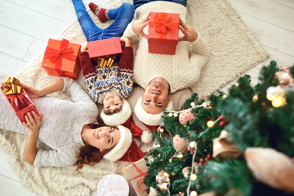 Familia con regalos en la habitación con un árbol de Navidad . — Foto de Stock