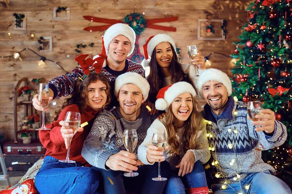 Amigos com copos de champanhe estão comemorando no Natal . — Fotografia de Stock