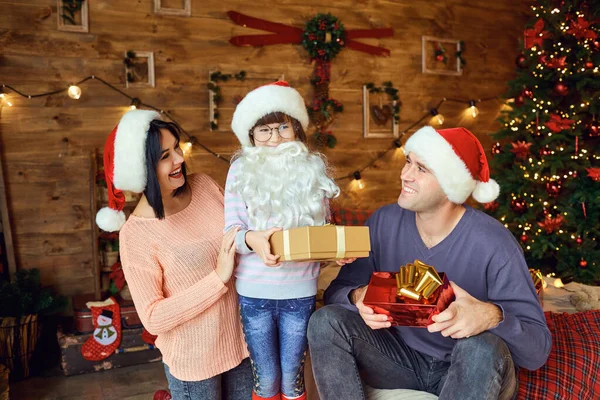 Мать и отец с ребенком дарят подарки на Рождество — стоковое фото