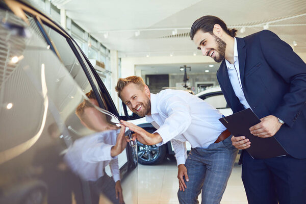 Автобизнес. Мужчина покупатель посмотрите на новый автомобиль
.