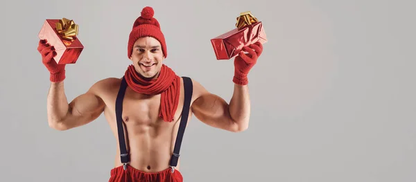 Homem atlético com presentes sorrindo no Natal . — Fotografia de Stock