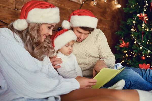 Happy family reading a book at Christmas. — Stock Photo, Image