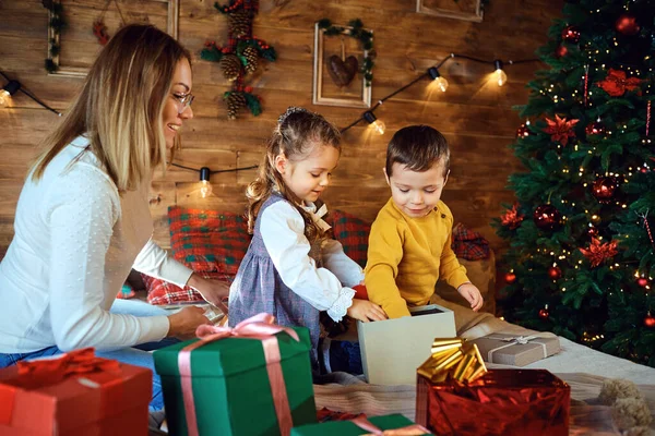 Mãe e crianças com presentes na casa para o Natal — Fotografia de Stock