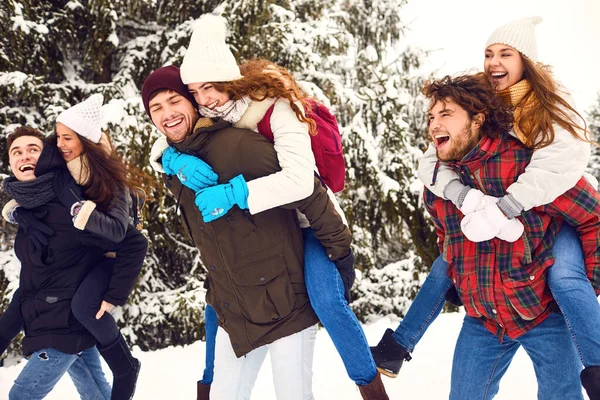 Brincalhão homens e mulheres se divertindo na floresta de inverno — Fotografia de Stock