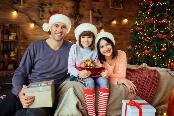 Родители с ребенком с подарками комнату на Рождество. — стоковое фото