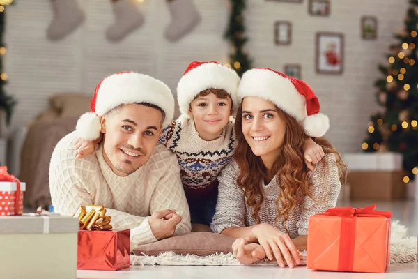 Feliz familia sonriendo tirada en el suelo en Navidad — Foto de Stock