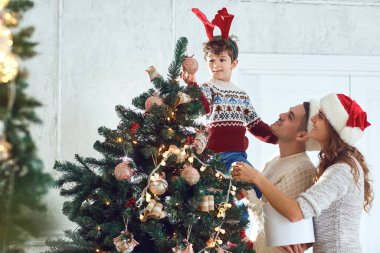 Kazaklı aile evdeki Noel ağacını boyar..