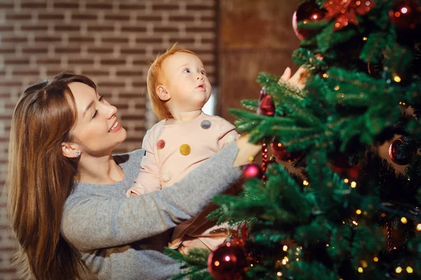 Glimlachende moeder tonen kerstboom aan baby — Stockfoto