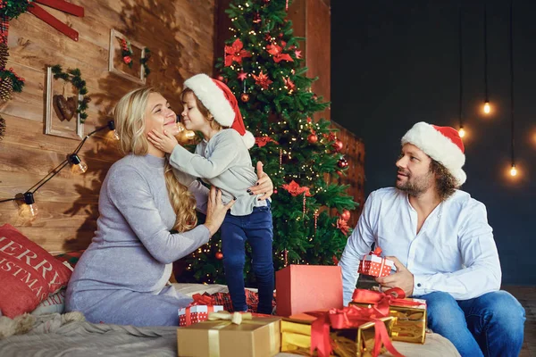 Moeder en vader geven een kind een cadeautje met Kerstmis — Stockfoto