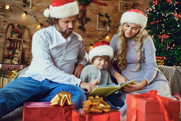 Rodina čte knihu doma o Vánocích — Stock fotografie