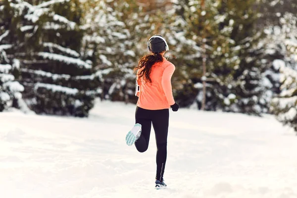 Girl jogging in the snow on the nature in winter.Back view — Stock Photo, Image