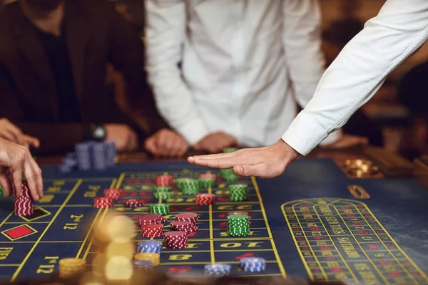 Croupiers gesto mão sobre a mesa com chips de roleta . — Fotografia de Stock