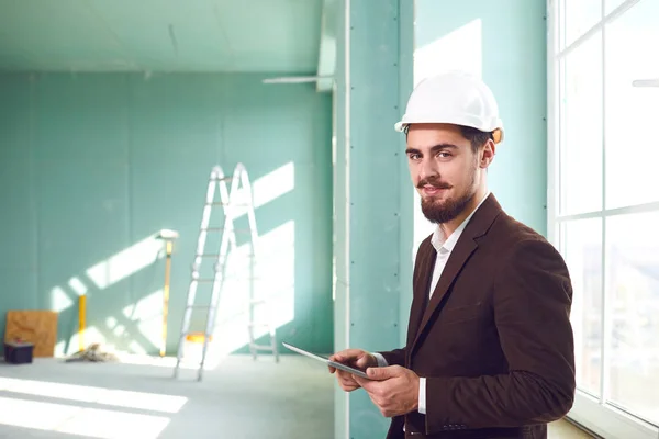 Polier bärtiger Mann mit weißem Helm in einem Raum auf einer Baustelle — Stockfoto