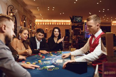 İnsanlar kumarhanede poker masasında kumar oynarlar.