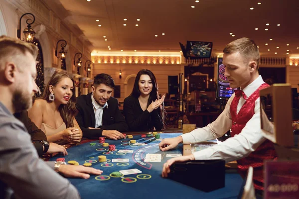 Az emberek egy kaszinó pókerasztalánál játszanak. — Stock Fotó