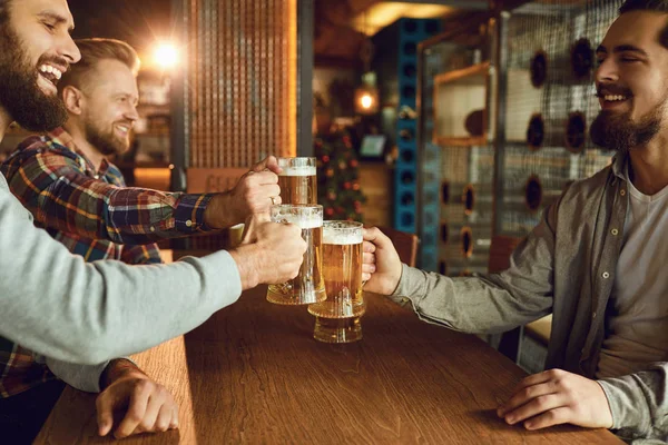 Amigos de grupo batendo copos de cerveja em um bar . — Fotografia de Stock