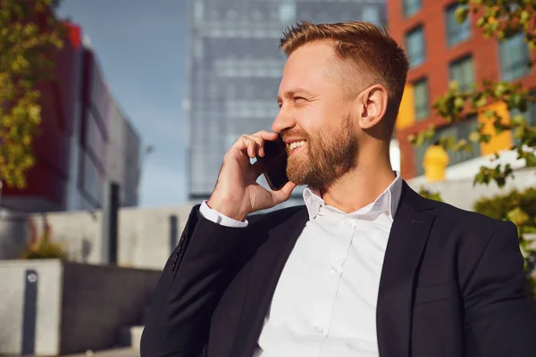 Geschäftsmann telefoniert vor dem Hintergrund eines Geschäftshauses — Stockfoto
