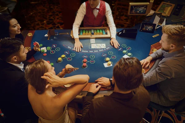 Group of people gambling sitting at a table in a casino top view — Stock Photo, Image