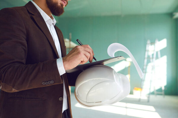 Строитель пишет на бумаге в помещении на строительной площадке в помещении
.