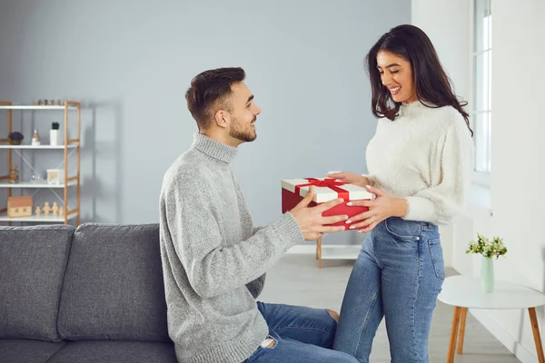 Valentines day. A young couple gives a gift in a room — 스톡 사진