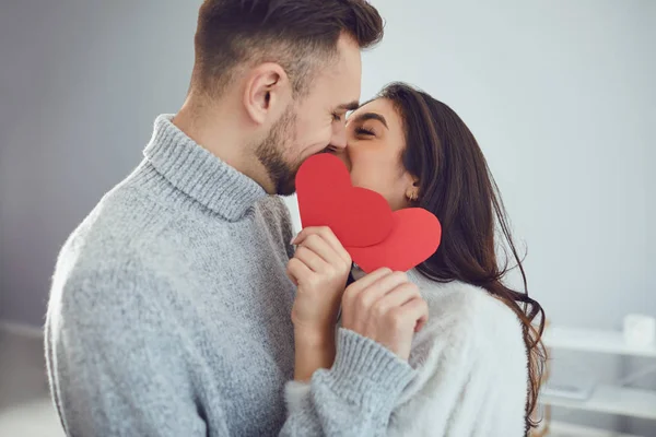 Saint Valentin. Couple aimant avec des cœurs dans la main baisers dans la chambre — Photo