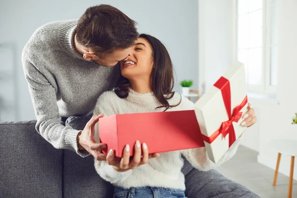 Valentýn. Mladý pár dává dárek v pokoji — Stock fotografie