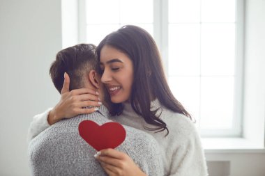 Sevgililer Günü. Kalpleri olan sevgi dolu bir çift odada sarılıyor..
